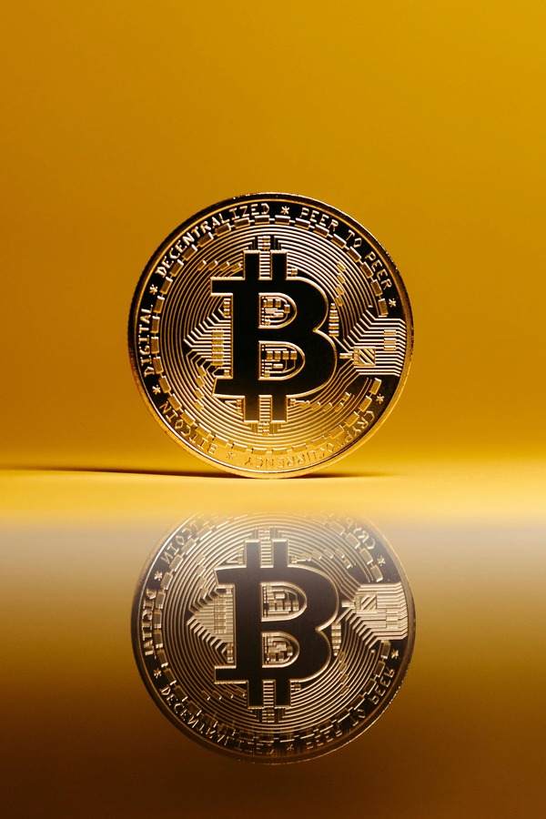 Hand holding a physical cryptocurrency coin against a dark background